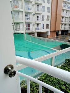 a balcony with a swimming pool in front of a building at Amara Cityland Prime Residences in Tagaytay