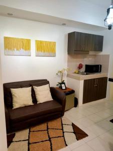 a living room with a couch and a kitchen at Amara Cityland Prime Residences in Tagaytay