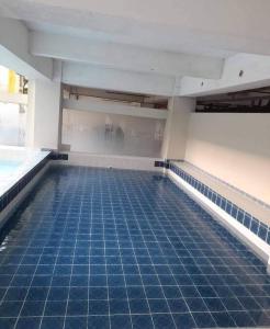 an empty swimming pool with blue tiles on the floor at Amara Cityland Prime Residences in Tagaytay