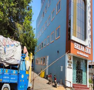 um camião azul estacionado em frente a um edifício em Selva Inn em Pondicherry