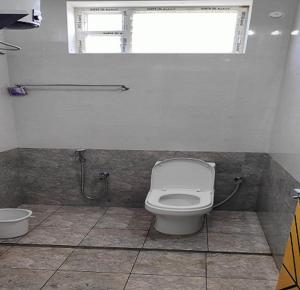 uma casa de banho com um WC e uma janela em Selva Inn em Pondicherry