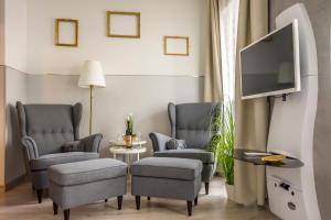 a living room with two chairs and a flat screen tv at K40 Romantic Deluxe Studio In the City Center in Budapest