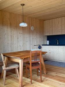 un tavolo in legno con 2 sedie e una cucina di Schallerhof Sterzing - Deine Auszeit mit Ausblick in unseren Ferienwohnungen auf dem Bergbauernhof in Südtirol a Vipiteno