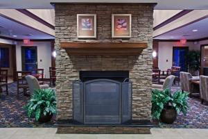 einen Steinkamin in der Hotellobby mit Pflanzen in der Unterkunft Staybridge Suites Fort Wayne, an IHG Hotel in Fort Wayne