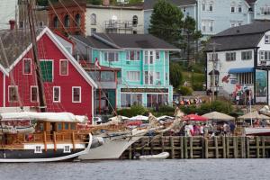 um barco ancorado numa doca em frente às casas em Brigantine Inn em Lunenburg