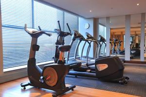 una palestra con diverse macchine cardio in una stanza di Holiday Inn Johannesburg-Rosebank, an IHG Hotel a Johannesburg