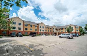 ein großes Gebäude mit Autos auf einem Parkplatz in der Unterkunft Extended Stay America Select Suites - New Orleans - Airport in Kenner