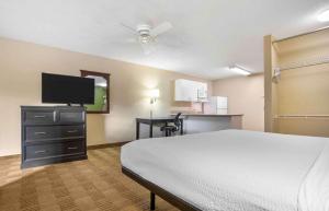 ein Hotelzimmer mit einem Bett und einem Flachbild-TV in der Unterkunft Extended Stay America Select Suites - New Orleans - Airport in Kenner