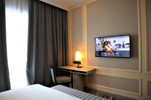 ein Hotelzimmer mit einem Bett und einem TV an der Wand in der Unterkunft KSL ESPLANADE HOTEL with HOT SPRING in Klang