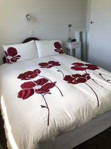 um quarto com uma cama com flores vermelhas em Horseinaround em Cambridge