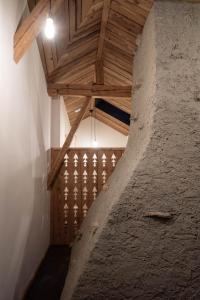 an attic room with a wooden ceiling and a staircase at Hôtel-Restaurant Le Cochon Rose in La Sagne