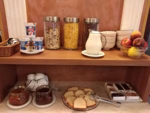 una mensola con barattoli di cibo e altri prodotti alimentari di Pensiunea Casa Rusu a Baia Mare