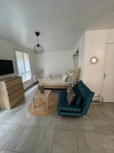 a living room with a bed and a chair at Grand Studio neuf in Aulnay-sous-Bois