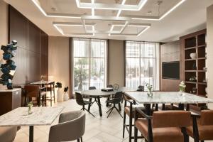 AC Hotel by Marriott New Orleans French Quarter في نيو أورلينز: قاعة اجتماعات مع طاولات وكراسي وتلفزيون