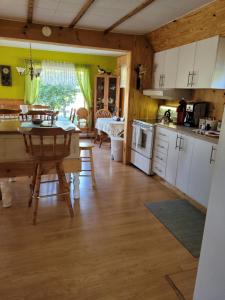 una cucina e una sala da pranzo con tavolo e sala da pranzo di Le Gîte Du Gardien Blanc a Saint-David-de-Falardeau