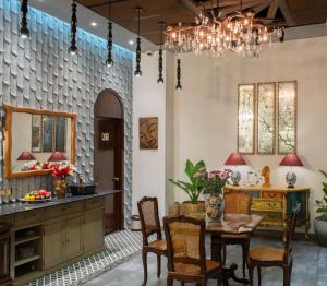 una sala da pranzo con tavolo, sedie e specchio di Aaron Boutique Hotel a Nha Trang