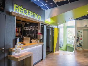 a restaurant with a reception counter in a store at ibis budget Site du Futuroscope in Chasseneuil-du-Poitou