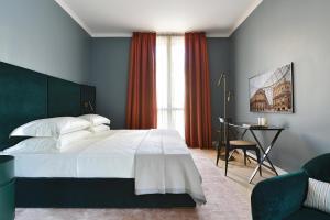 a bedroom with a large white bed and a desk at Casa Brivio in Milan