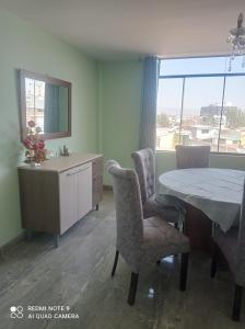 a dining room with a table and chairs and a window at DEPARTAMENTO EN YANAHUARA 3er piso in Arequipa