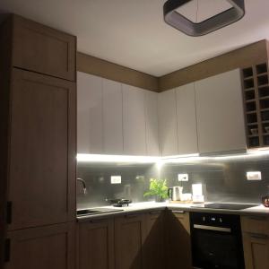 cocina con armarios blancos y fogones en Apartament Patio Vita -garaż podziemny, taras,wejście klamka kod,centrum, en Kielce