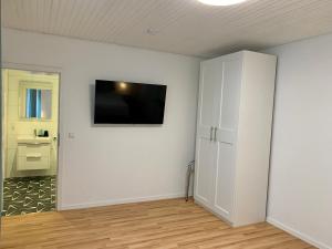 a room with a white wall with a flat screen tv at Apartment Brauselay in Cochem