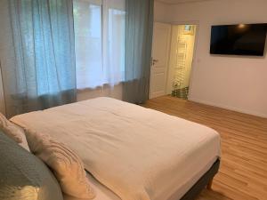 a bedroom with a white bed and a television at Apartment Brauselay in Cochem