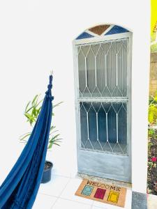 a blue hammock next to a door with a window at Carvalho de Paquetá in Rio de Janeiro