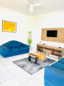 a living room with two blue couches and a tv at Carvalho de Paquetá in Rio de Janeiro