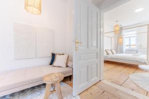 a white living room with a couch and a chair at Gran.Suite - Central Station in Sankt Pölten