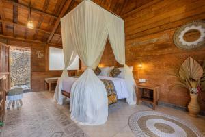 una camera in legno con letto a baldacchino. di Jukung Cottage a Nusa Penida