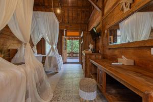 una camera con letto e soffitto in legno di Jukung Cottage a Nusa Penida