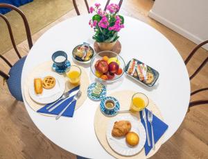 - une table blanche avec des aliments et des boissons pour le petit-déjeuner dans l'établissement AI PALMENTI B&B, à Adelfia