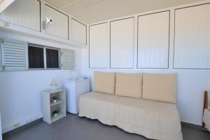 um quarto branco com uma cama e armários brancos em Ria Beach Studio em Faro