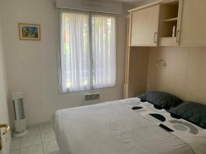 um quarto com uma grande cama branca e uma janela em Le Tropical em Fréjus