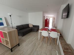 a living room with a couch and a table and chairs at Tomarhousing - 37 Old Town in Tomar