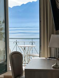 Zimmer mit einem Tisch und Meerblick in der Unterkunft Hotel Eden Palace au Lac in Montreux