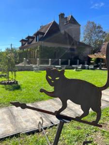 Eine schwarze Katze steht auf einem Stand vor einem Haus in der Unterkunft chambre d'hôtes Madame in Branges