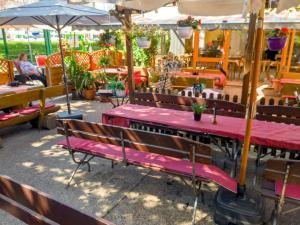 un restaurant avec des bancs, des tables et des parasols dans l'établissement Alt Wehlheiden, à Cassel