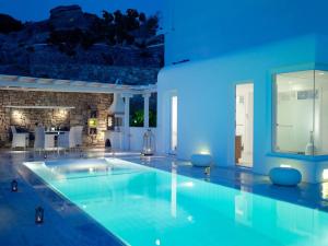 - une piscine dans une maison à l'éclairage bleu dans l'établissement Mykonos Grand Hotel & Resort, à Agios Ioannis Mykonos