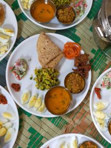 a table with plates of food on a table at Trident Jungle Stay in Dandeli