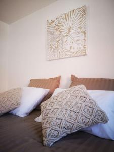 ein Bett mit Kissen und ein Bild an der Wand in der Unterkunft T3 - Appartement jardin Wissant 6 personnes in Wissant