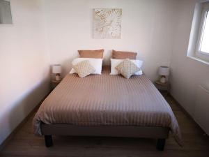 ein Schlafzimmer mit einem großen Bett mit Kissen in der Unterkunft T3 - Appartement jardin Wissant 6 personnes in Wissant