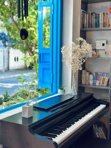 un piano sentado en una mesa con una puerta azul en Loka Home & Yoga, en Da Nang