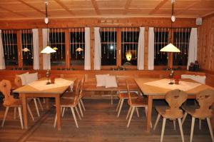 a dining room with wooden tables and chairs and windows at Villa Natur in Schröcken