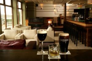 dois copos de cerveja numa mesa num bar em Inishbofin House Hotel em Inishbofin