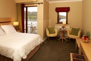 um quarto de hotel com uma cama, uma mesa e cadeiras em Inishbofin House Hotel em Inishbofin