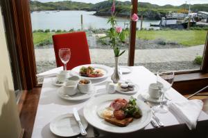 uma mesa com pratos de comida e vista para a água em Inishbofin House Hotel em Inishbofin