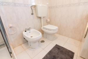 a small bathroom with a toilet and a sink at Tilli'n'Joe's Beach House in Atouguia da Baleia