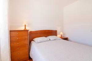 a bedroom with a bed and a dresser and two lamps at Tilli'n'Joe's Beach House in Atouguia da Baleia