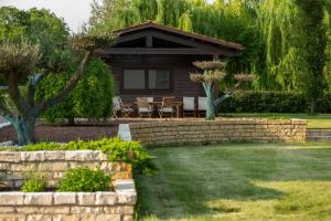 a house with a stone retaining wall in the yard at Il Filo Rosso B&B in Abano Terme